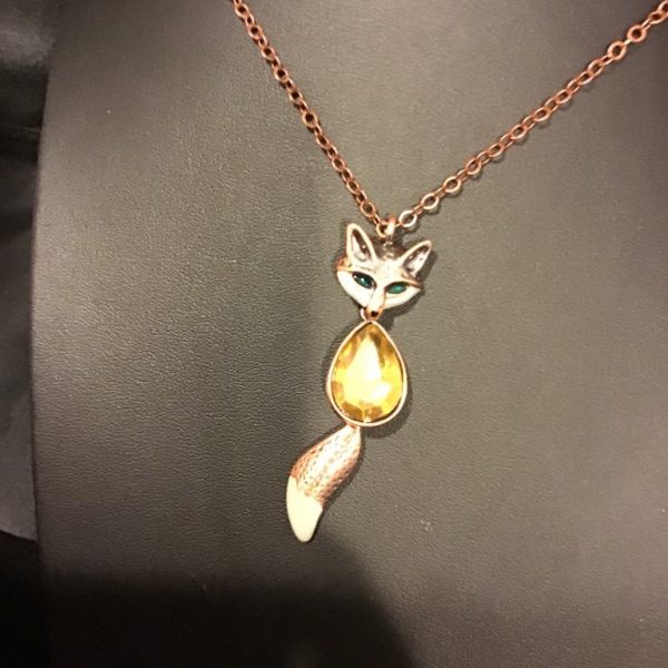 Playfully chic, this "Foxy Glow Pendant Necklace" dazzles with a fox-inspired design, featuring vibrant details and a golden teardrop gem for a touch of wild elegance.