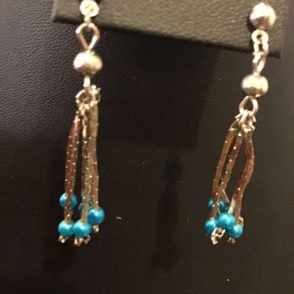 Delicate dangle earrings with shimmering metallic strands and vibrant turquoise-hued beads for a graceful, flowing look.