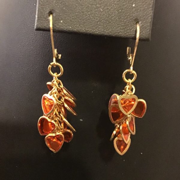 Charming gold-tone dangle earrings with cascading amber-hued heart charms, perfect for a romantic and playful touch.