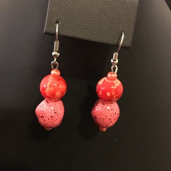 Bold and playful dangle earrings featuring glossy red and speckled pink beads for a vibrant, retro-inspired look.