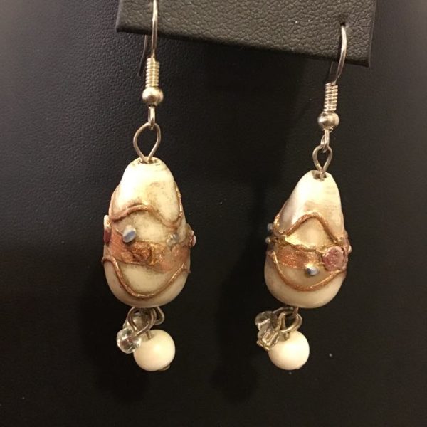 Artistic drop earrings featuring decorated seashell-like beads with metallic accents and pearl dangles, perfect for a vintage coastal look.