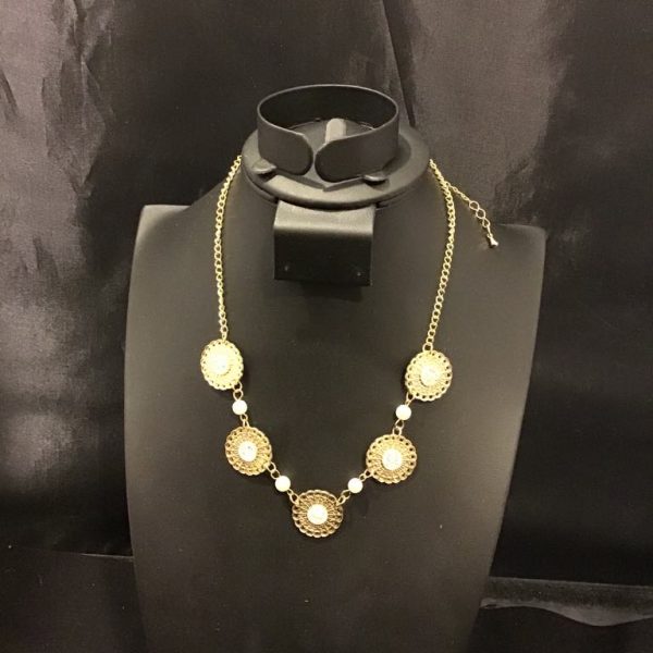 A vintage-inspired filigree necklace with golden medallions and pearl-like accents, perfect for adding timeless elegance to any outfit.