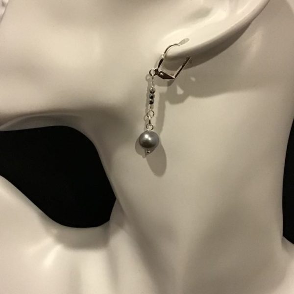 Graceful and sophisticated, these dangling earrings feature a delicate chain with a dark pearl-like drop, perfect for adding a touch of vintage elegance to any outfit.