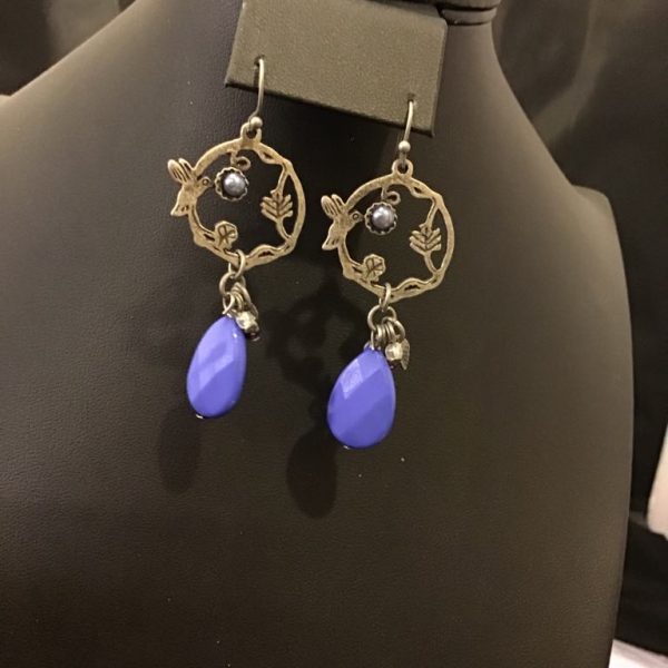 Vintage-inspired filigree earrings with floral detailing, pearl accents, and striking blue teardrop dangles for a touch of elegance and whimsy.