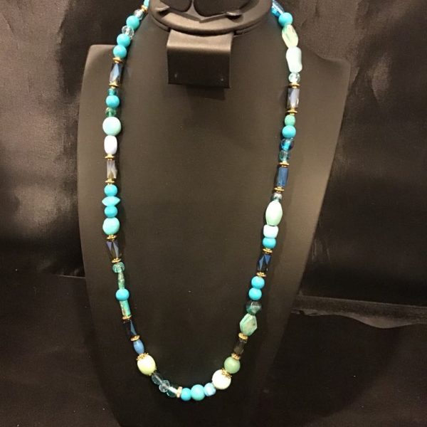 A mesmerizing blend of turquoise, aqua, and deep blue beads with gold accents, perfect for adding a touch of ocean-inspired elegance to any outfit.
