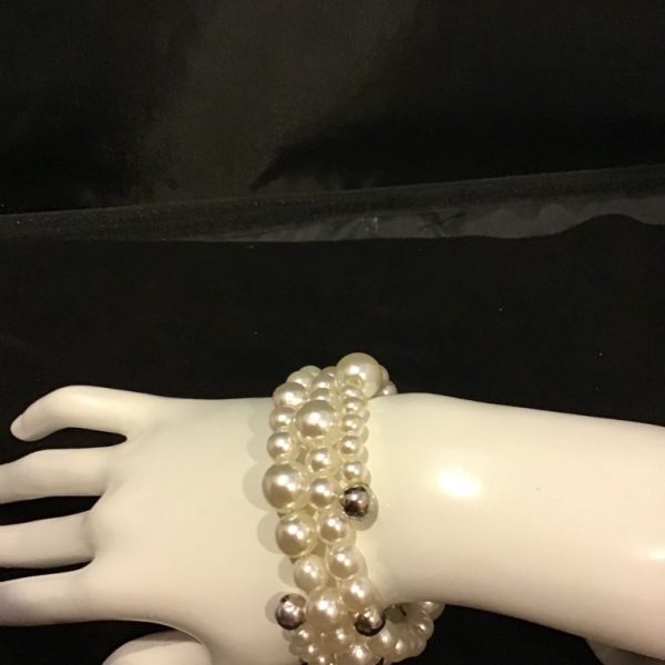A luxurious wrap-around bracelet featuring luminous faux pearls and metallic accents, perfect for vintage glamour with a modern twist.