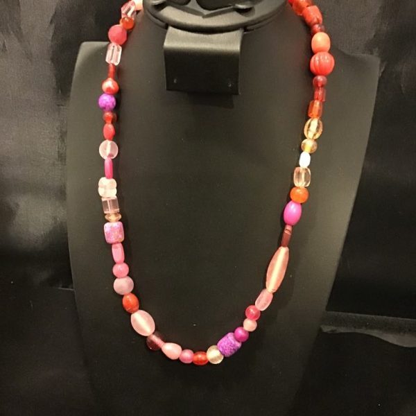 A stunning mix of pink, red, and purple beads in various shapes and sizes, this eclectic necklace adds a bold and playful touch to any outfit.