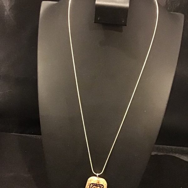 Channel strength and sophistication with this Regal Roar Pendant Necklace, featuring a striking lion motif on a natural-toned charm, suspended from a delicate chain.
