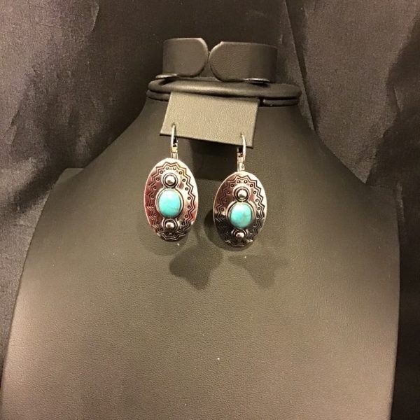 Bold and beautifully detailed, these vintage-inspired turquoise drop earrings exude Southwestern charm with intricate metal etching and a rustic finish.