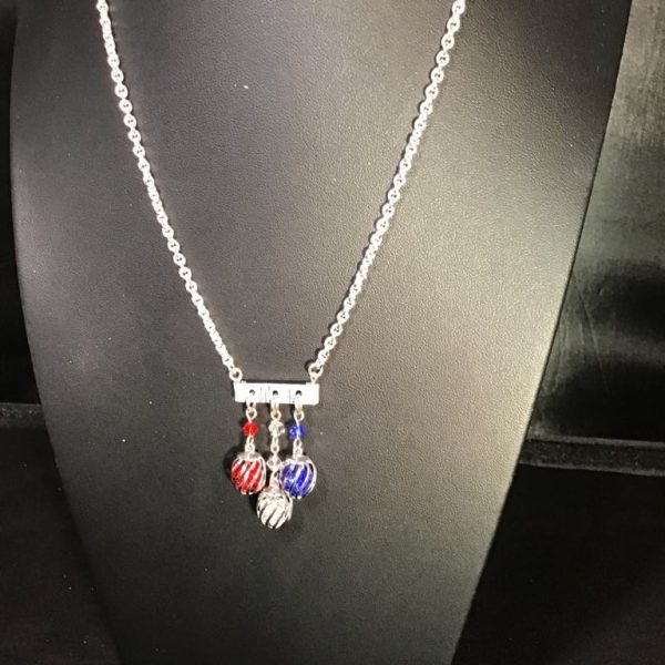 Add a pop of playful sparkle to your look with the Patriotic Sparkle Trio Necklace, featuring vibrant red, white, and blue dangles on a silver-tone chain.