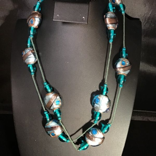 Turn heads with our Turquoise Mirage Beaded Necklace, a double-strand showstopper featuring metallic silver, bronze, and turquoise beads for a vibrant bohemian flair.